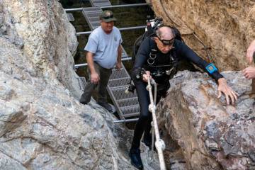 National Park Service biologist Kevin Wilson helps volunteer-in-park diver Mal Maloney traverse ...