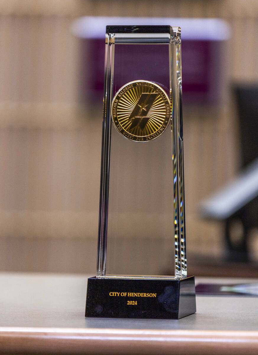 The 2024 Malcolm Baldrige National Quality Award is displayed before a room of attendees as the ...