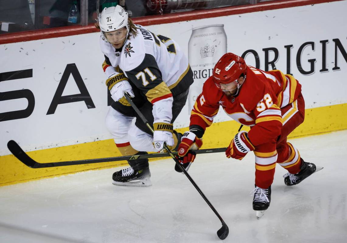 Vegas Golden Knights' William Karlsson (71) and Calgary Flames' MacKenzie Weegar (52) chase the ...