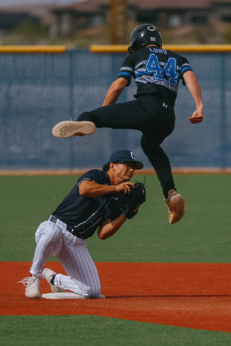 Basic’s Brandon Lord (44) leaps over Centennial second baseman Noa Oyadomari (5) to avoi ...