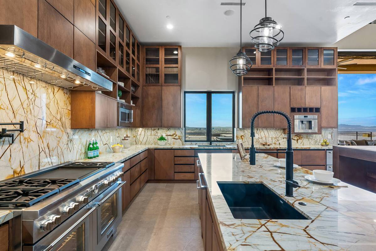 The kitchen's sophisticated design boasts custom walnut finish cabinetry, integrated appliances ...