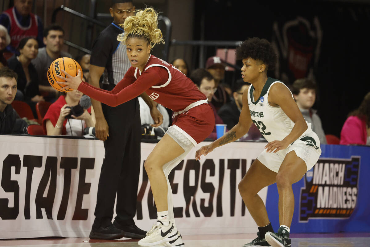 Harvard's Harmoni Turner, left, works the ball against Michigan State's Nyla Hampton (22) durin ...