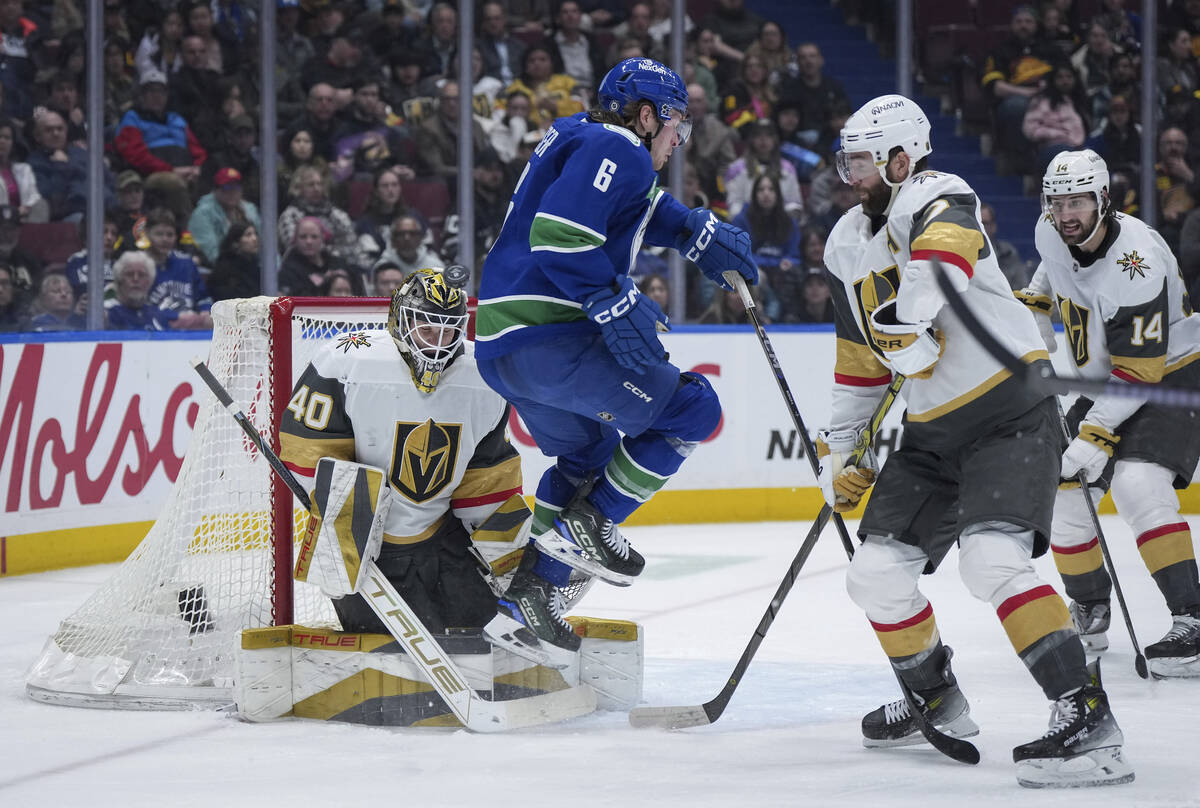 Vancouver Canucks' Brock Boeser (6) jumps in front of Vegas Golden Knights goalie Akira Schmid ...
