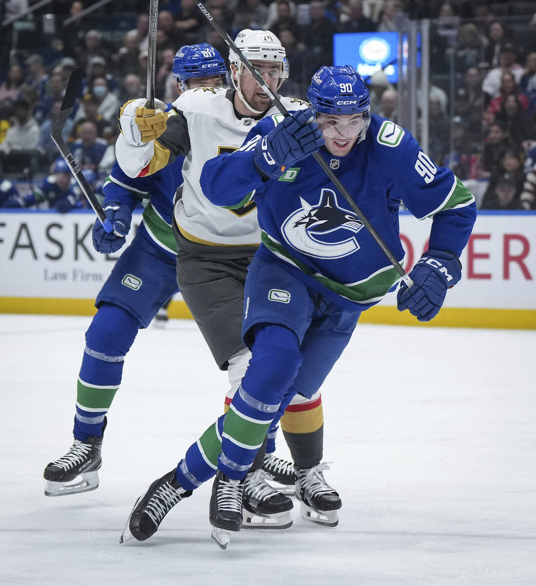 Vancouver Canucks' Vittorio Mancini, front, skates after the puck while being watched by Vegas ...