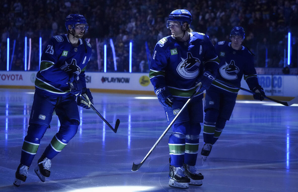 Vancouver Canucks' Brock Boeser, front right, Marcus Pettersson, left, and Drew O'Connor, back ...