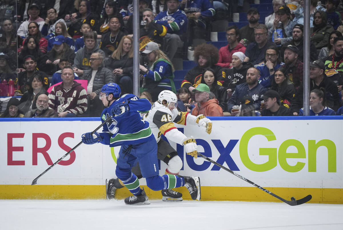 Vegas Golden Knights' Jonas Rondbjerg, back right, avoids a check by Vancouver Canucks' Vittori ...