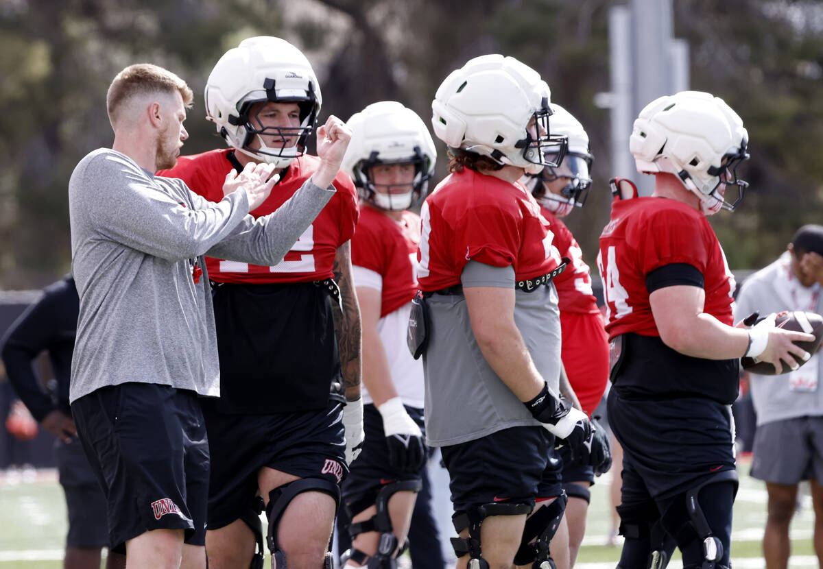 UNLV football offensive line coach Mike Sollenne discusses with offensive line Will Thomas (72) ...