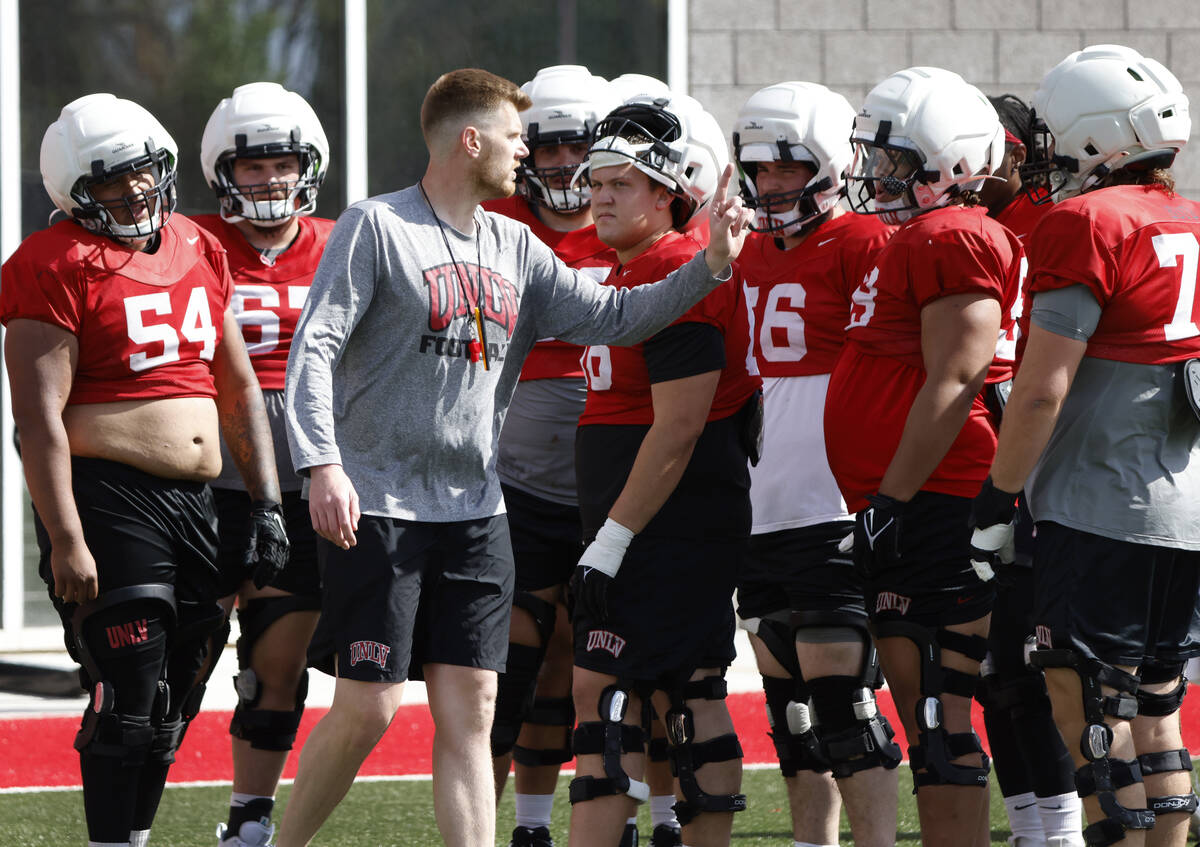 UNLV football offensive line coach Mike Sollenne talks to his players during spring practice at ...