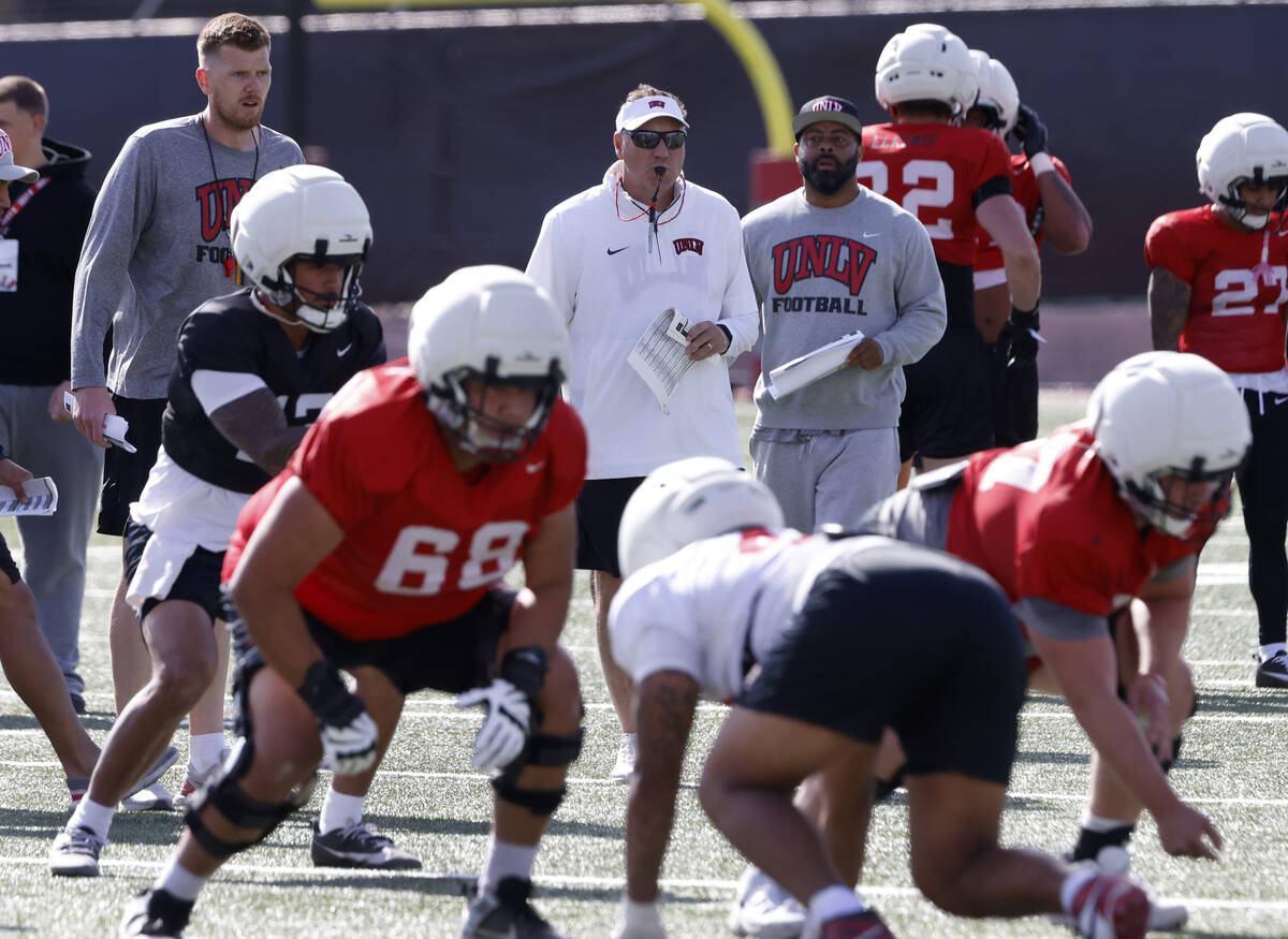 UNLV football offensive line coach Mike Sollenne, left, and head coach Dan Mullen watch their p ...