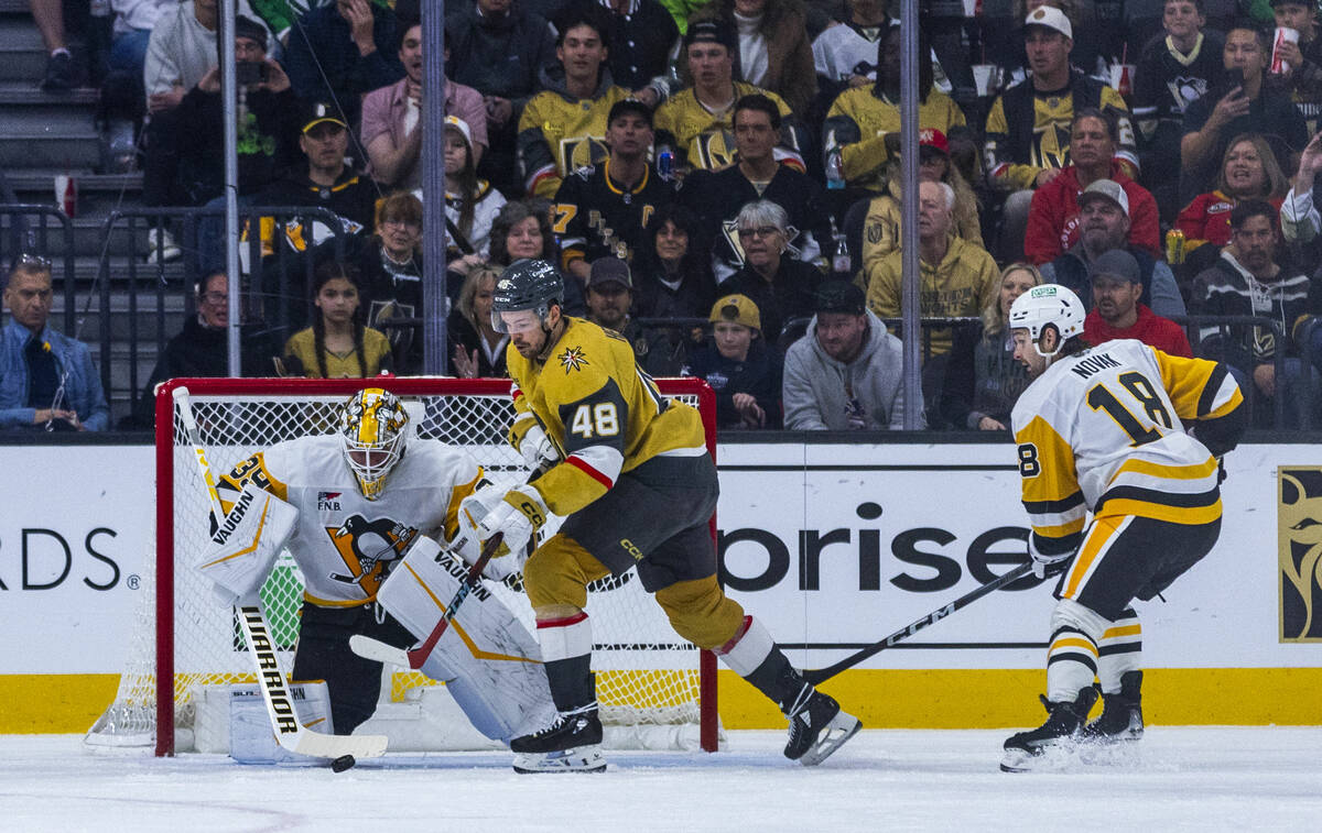 Pittsburgh Penguins goaltender Alex Nedeljkovic (39) deflects a shot with Golden Knights center ...