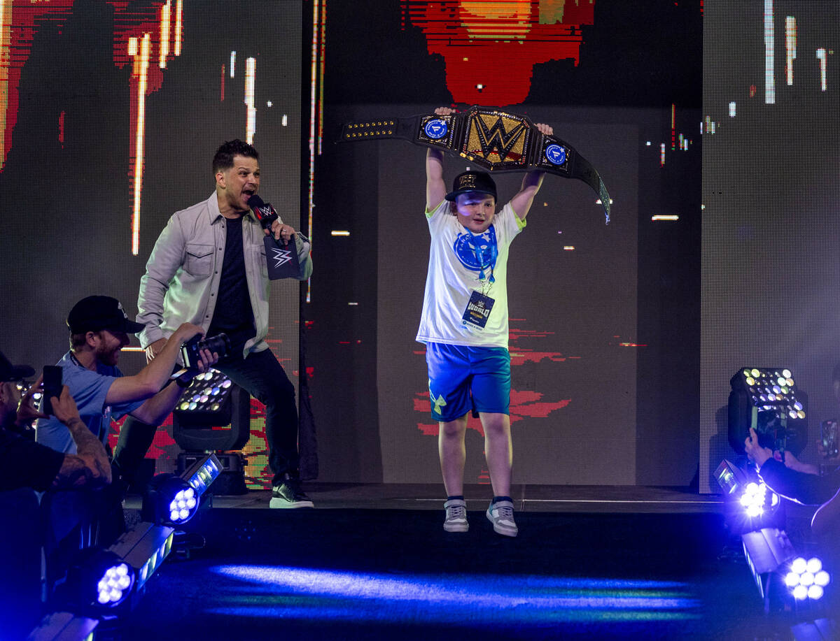 Make-A-Wish kid "King Kid" holds his title belt high as he's introduced by announcer ...