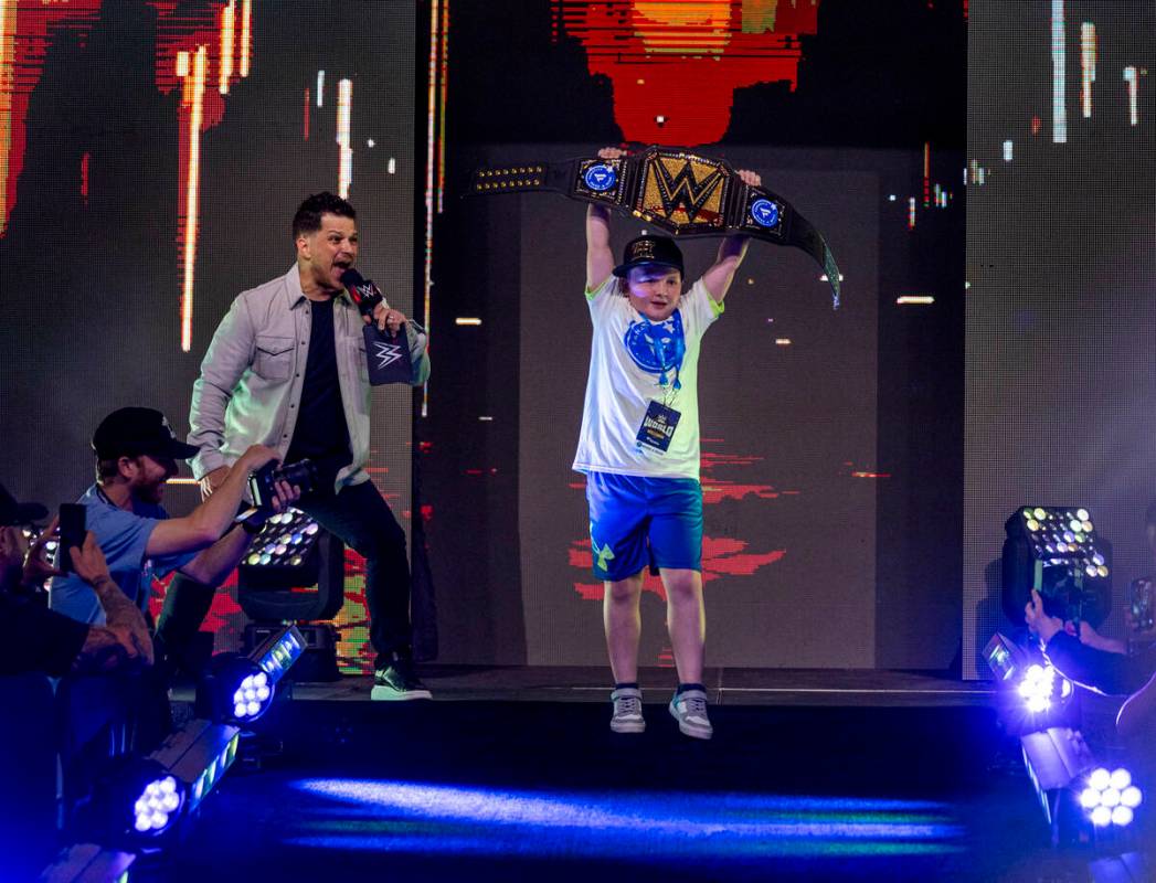 Make-A-Wish kid "King Kid" holds his title belt high as he's introduced by announcer ...