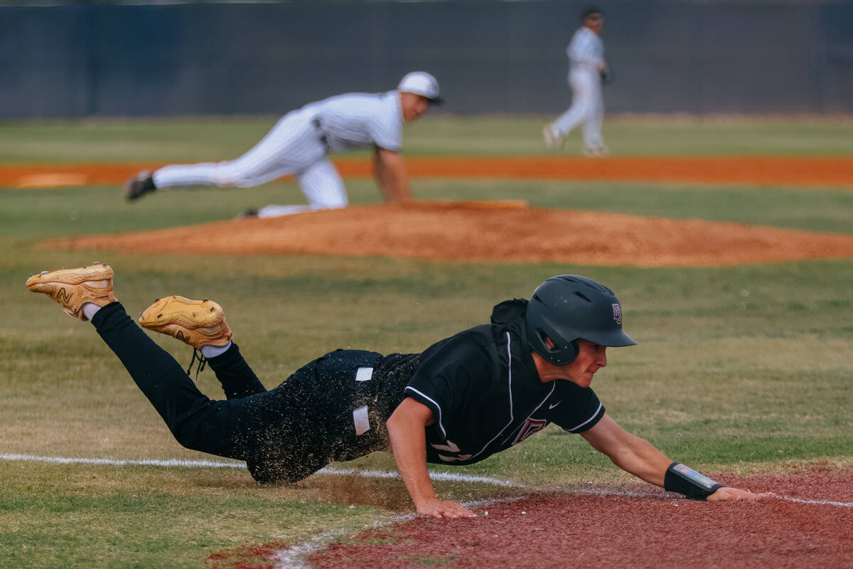 Desert Oasis’ Roenen Allen (11) slides toward home, earning the first run for the Diamon ...