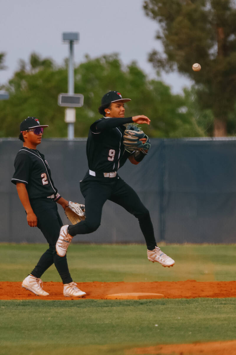 Desert Oasis second baseman Jayson Marquez (9) leaps to toss the ball to first base to attempt ...