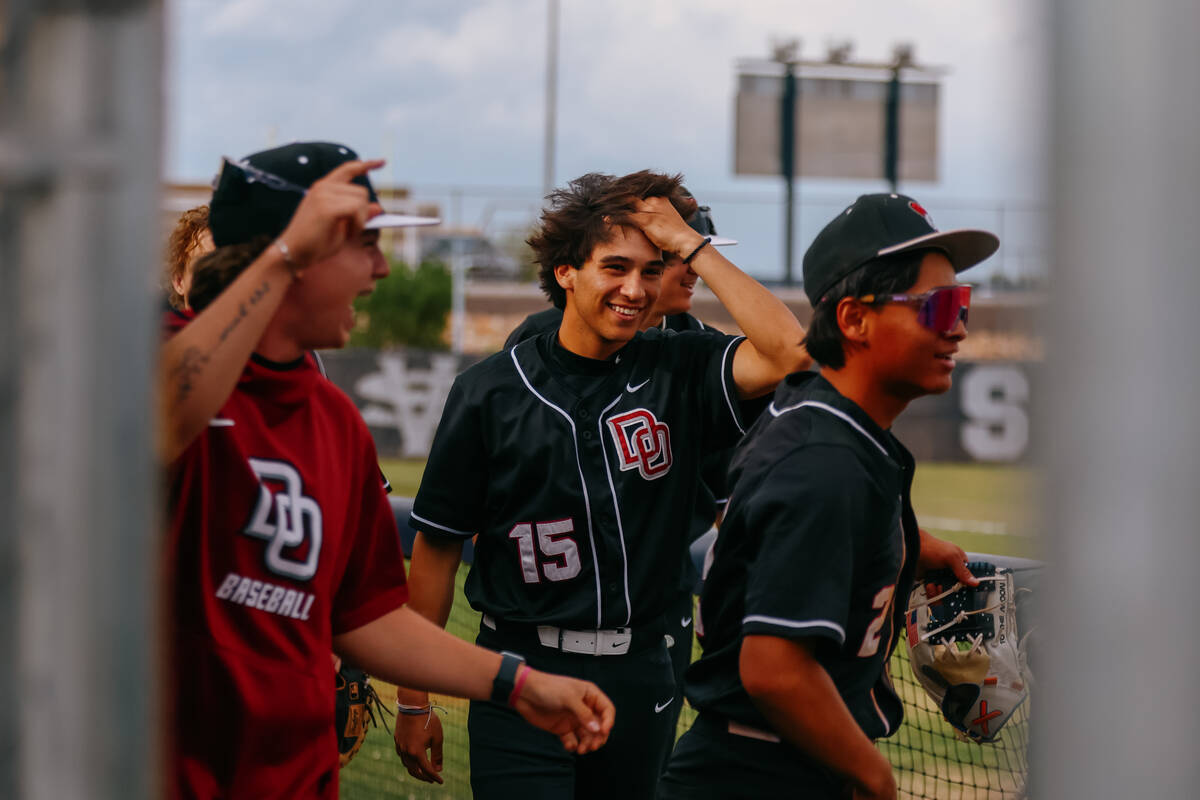 Desert Oasis’ Ashton Kidd (15), center, and the rest of the dugout walk out to celebrate a ho ...