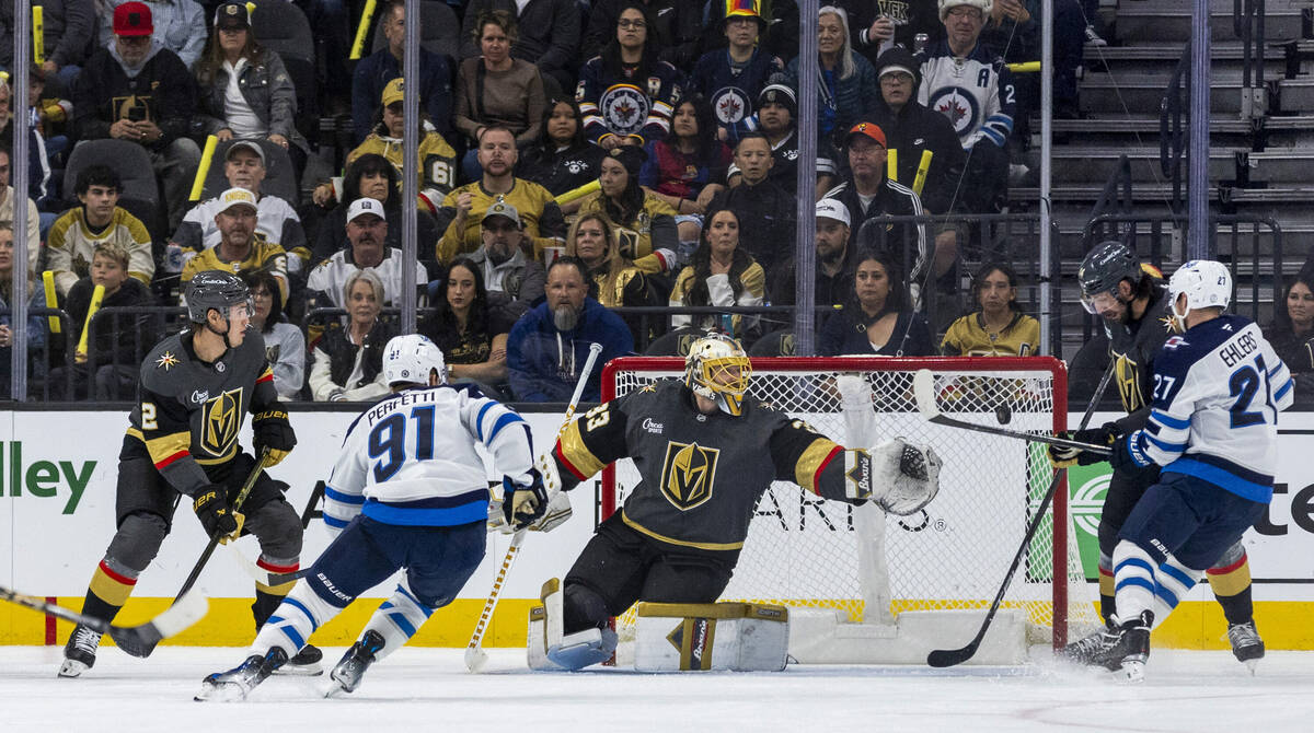 Golden Knights goaltender Adin Hill (33) is unable to stop a shot with Winnipeg Jets left wing ...