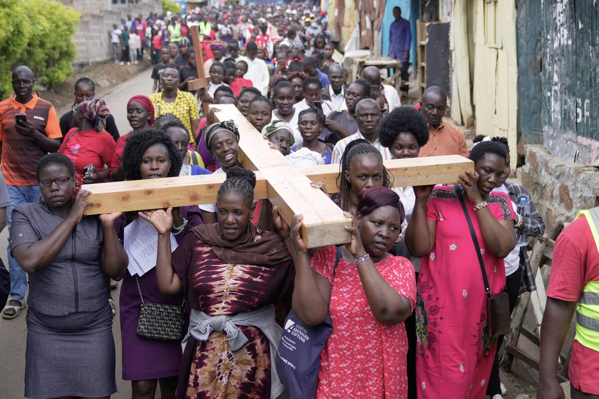 Christians carry a cross at a Good Friday procession during Holy Week in the Kibera informal se ...