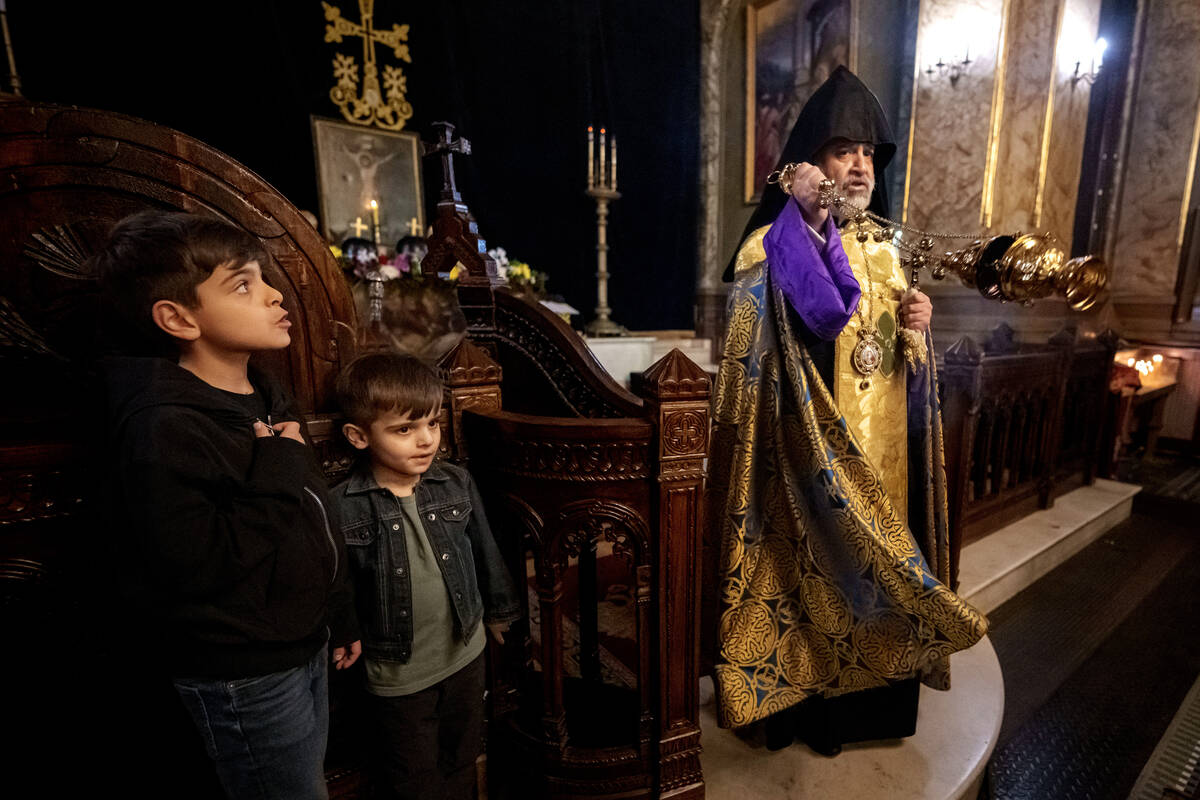 Children stand as Iraq-born Archbishop Datev Hagopian performs the Good Friday religious servic ...