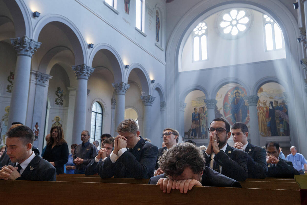 Light streams through windows as worshippers pray during the Good Friday celebration of the Lor ...