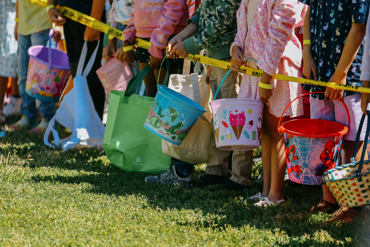 Children between the ages of seven and eight hold colorful buckets, ready to pounce on some egg ...