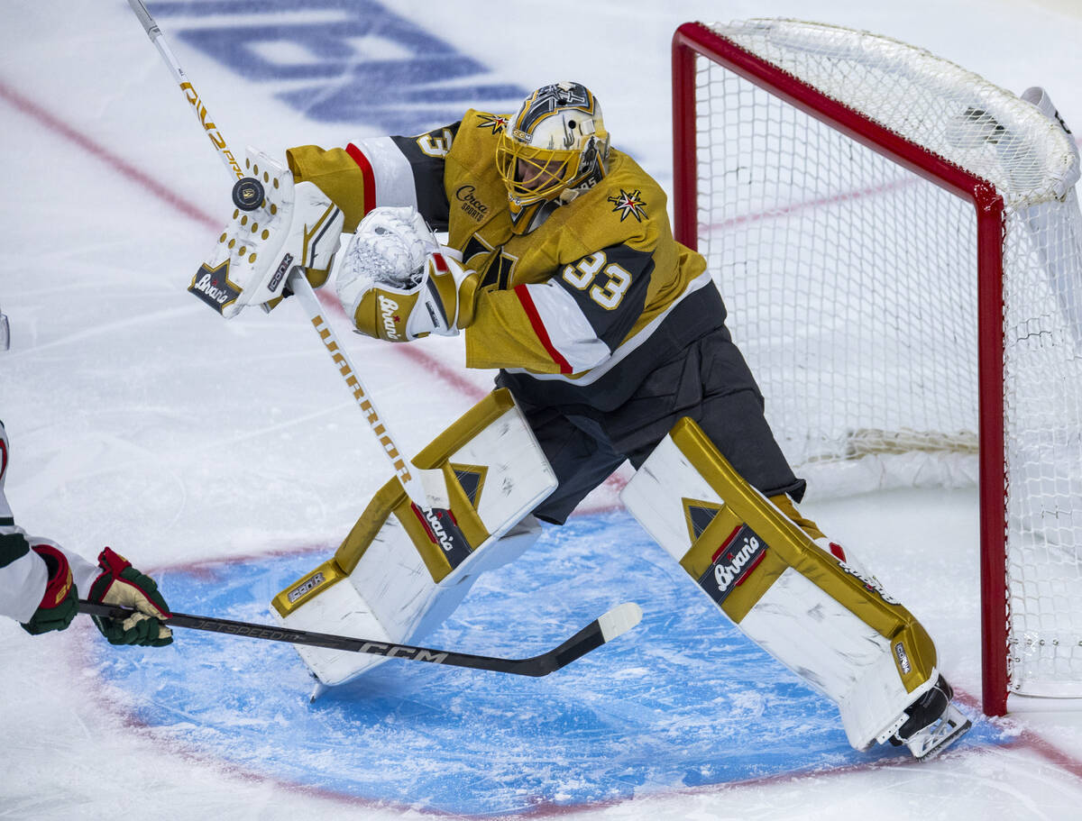 Golden Knights goaltender Adin Hill (33) deflects a shot off his pad against the Minnesota Wild ...