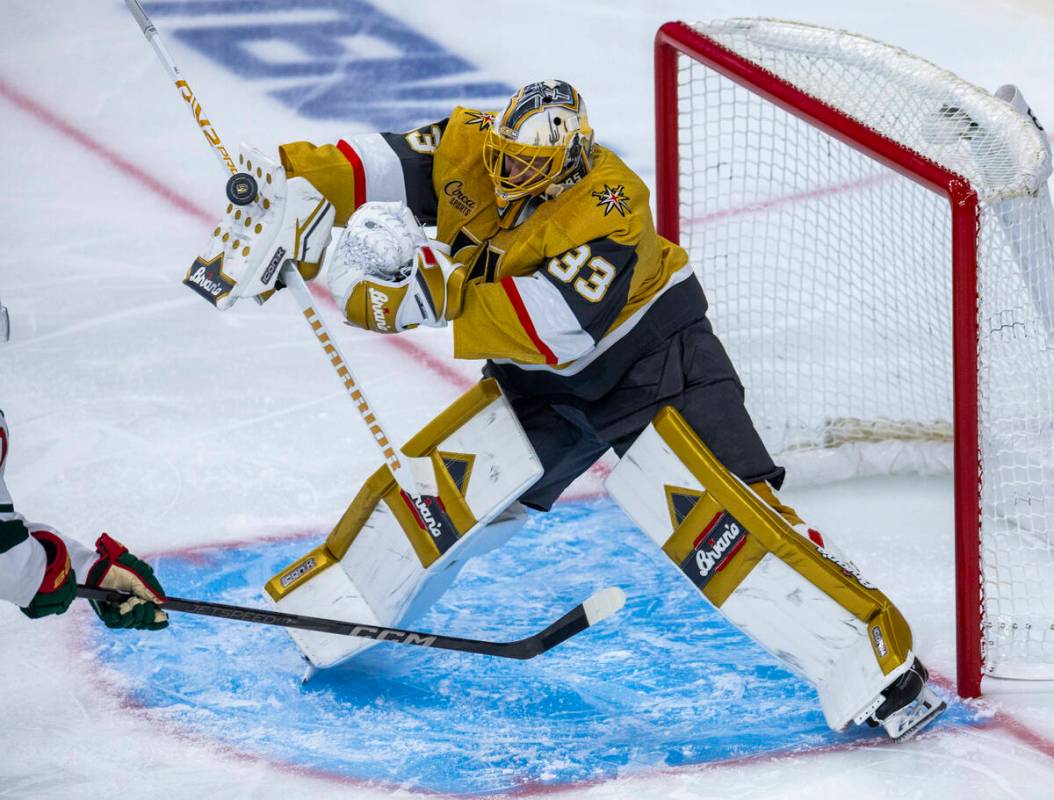 Golden Knights goaltender Adin Hill (33) deflects a shot off his pad against the Minnesota Wild ...