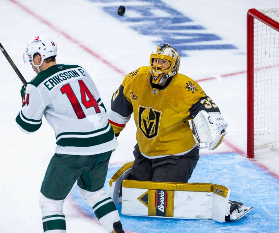 Golden Knights goaltender Adin Hill (33) looks to a high puck with Minnesota Wild center Joel E ...