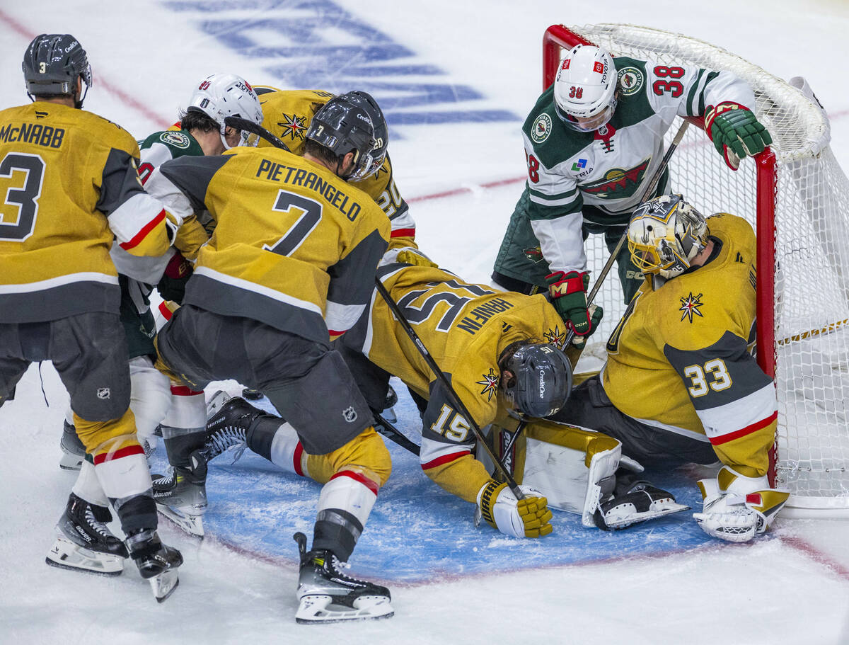Golden Knights goaltender Adin Hill (33) defends the net as Minnesota Wild right wing Ryan Hart ...