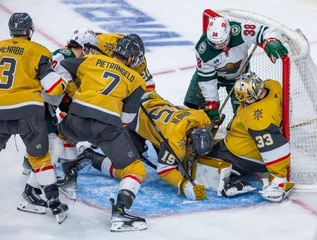 Golden Knights goaltender Adin Hill (33) defends the net as Minnesota Wild right wing Ryan Hart ...