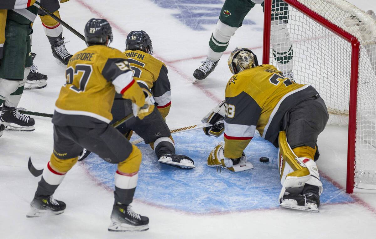 Golden Knights goaltender Adin Hill (33) has a puck slide past by the Minnesota Wild during the ...
