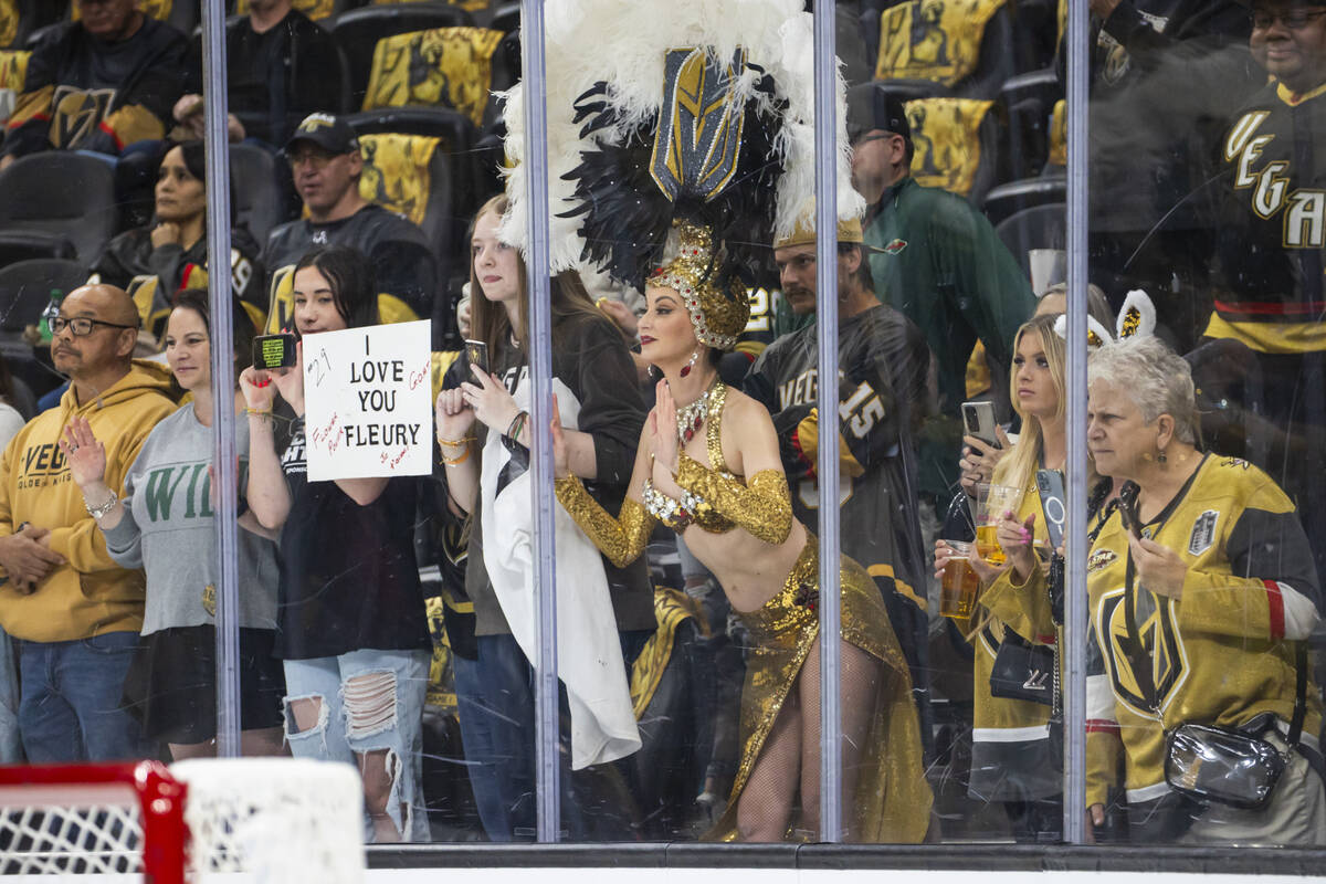 A Golden Belles showgirl watches as Minnesota Wild players warm up before their first-round NHL ...