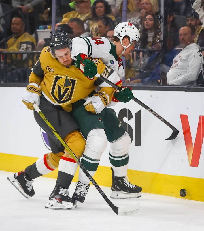 Golden Knights center Brett Howden (21) battles for the puck against Minnesota Wild center Joel ...