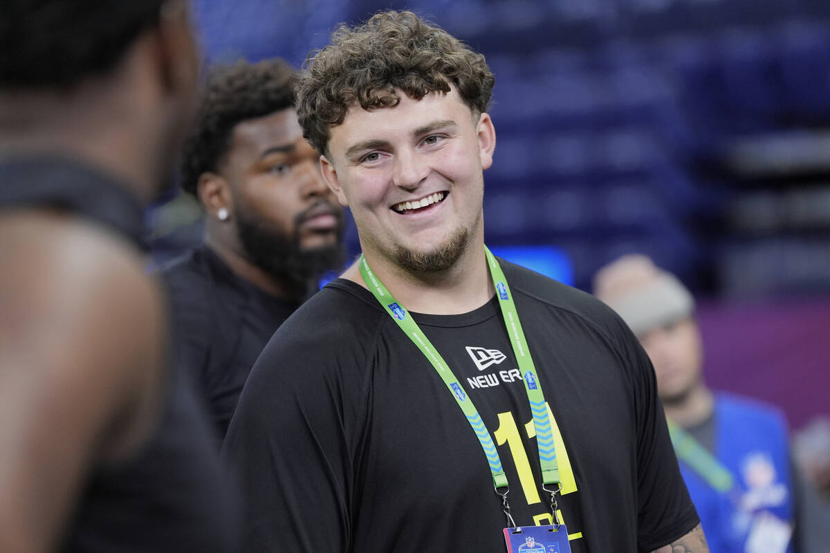 Michigan defensive lineman Mason Graham chats with others as he waits to run a drill at the NFL ...