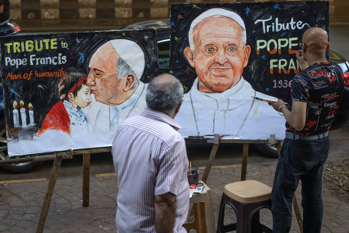 An Indian artist Sagar Kambli makes a painting of Pope Francis as a mark of tribute on a sidewa ...