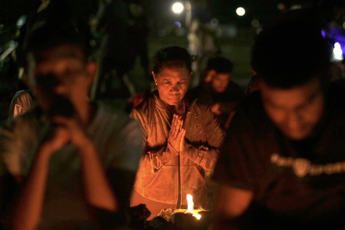 A woman prays during a vigil for the late Pope Francis in Dili, East Timor, Monday, April 21, 2 ...