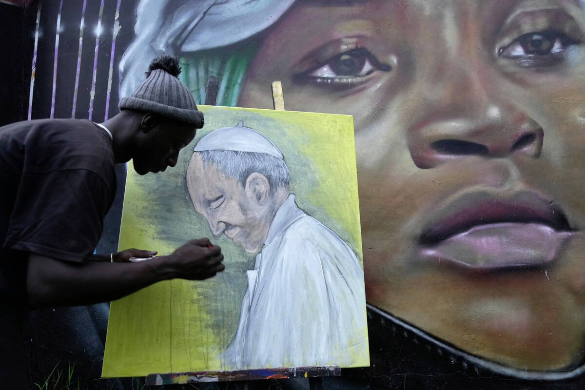 Graffiti artist Alexander Ikawah, paints Pope Francis on a canvas in Nairobi, Kenya Monday, Apr ...