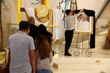 A photo of Pope Francis, who died at the age of 88, is shown draped in black bunting as worship ...