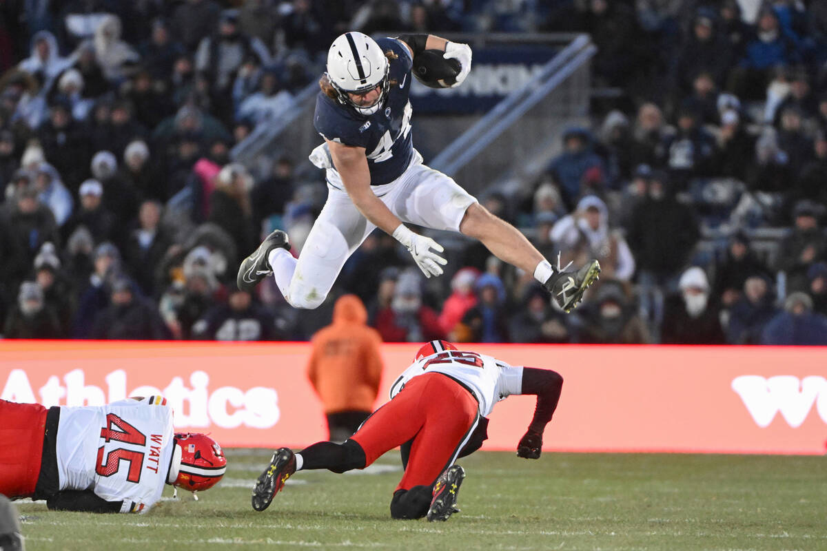 FILE - Penn State tight end Tyler Warren (44) hurdles Maryland defensive back Kevis Thomas (25) ...
