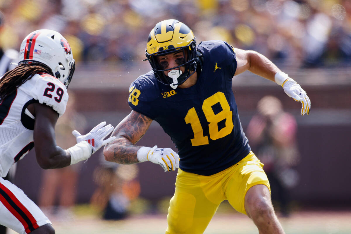 FILE - Michigan tight end Colston Loveland (18) maneuvers against Arkansas State safety Justin ...