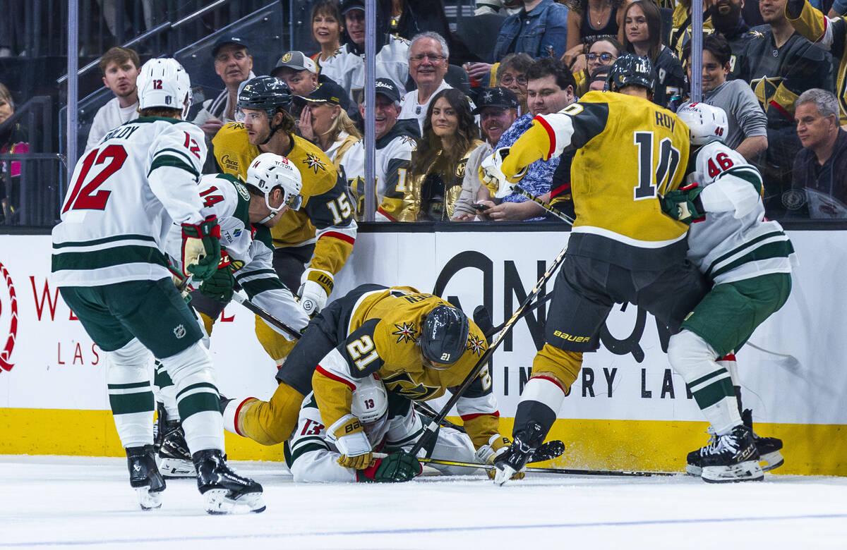 Golden Knights center Brett Howden (21) takes down Minnesota Wild center Yakov Trenin (13) as b ...