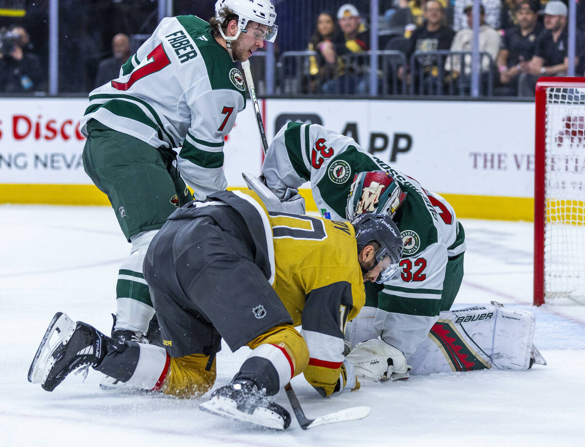 Golden Knights center Nicolas Roy (10) is knocked down after pursuing the puck smothered by Min ...
