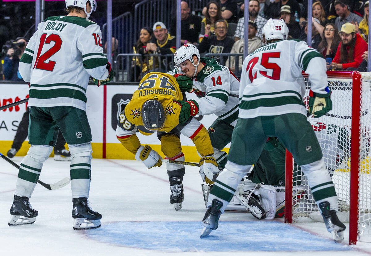 Golden Knights center Ivan Barbashev (49) is taken to the ice after a near score by Minnesota W ...