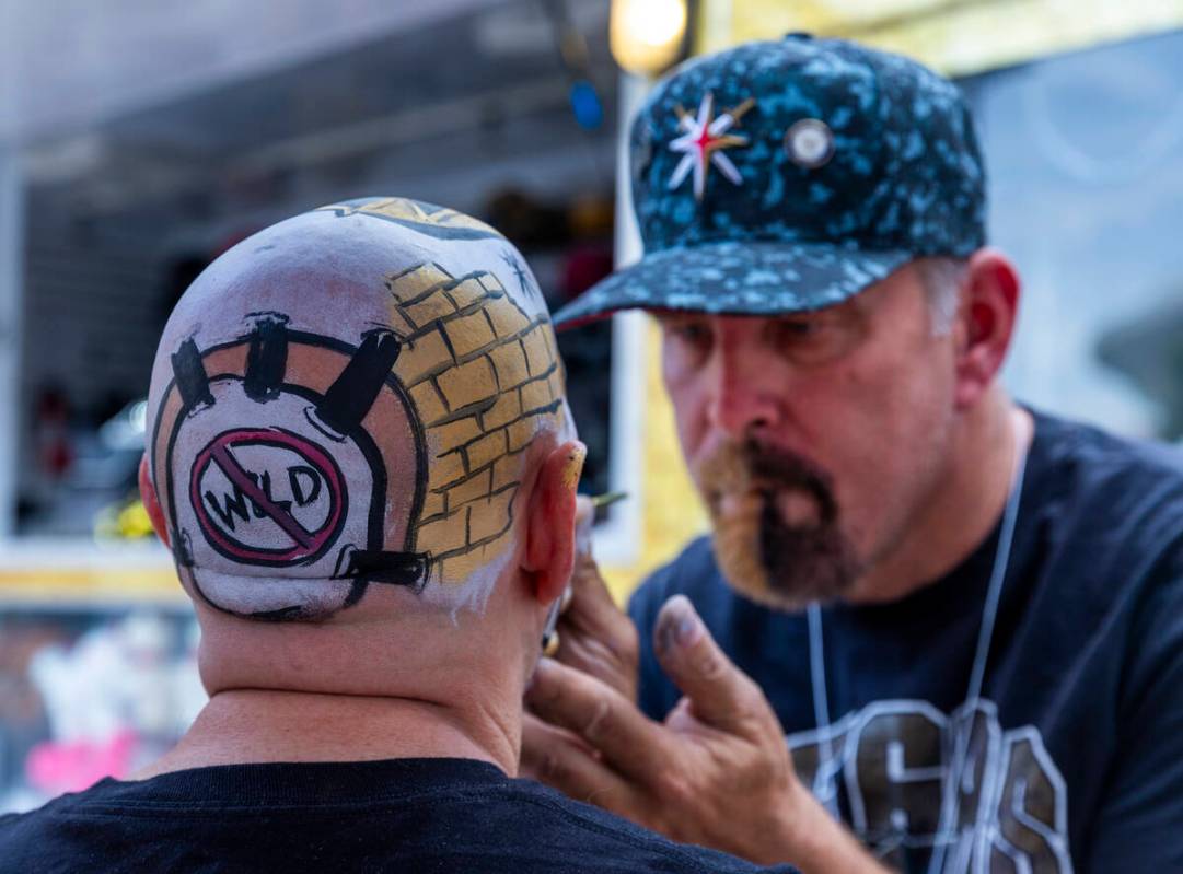 A fan has his head painted like a helmet during pre-game festivities outside before the Golden ...