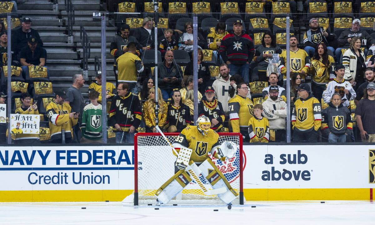 Golden Knights goaltender Adin Hill (33) has a wall of support as he fends off pucks during war ...