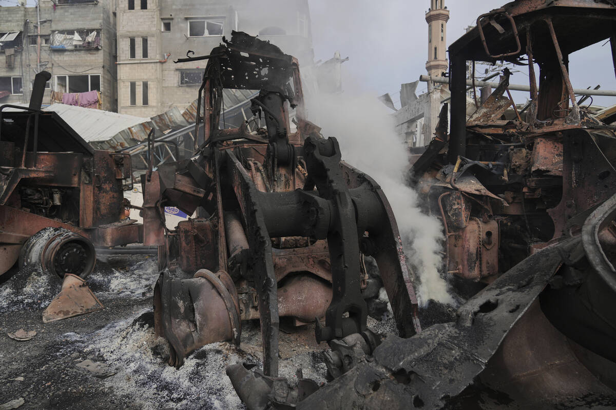 Smoke rises from the remains of bulldozers hit by an Israeli army airstrike in Jabaliya, northe ...
