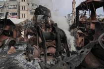 Smoke rises from the remains of bulldozers hit by an Israeli army airstrike in Jabaliya, northe ...
