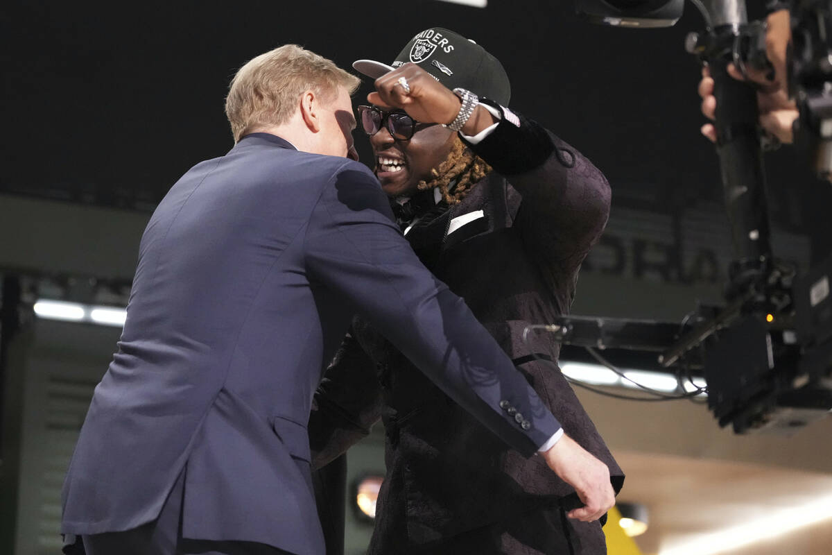 Boise State running back Ashton Jeanty, right, embraces NFL Commissioner Roger Goodell after be ...