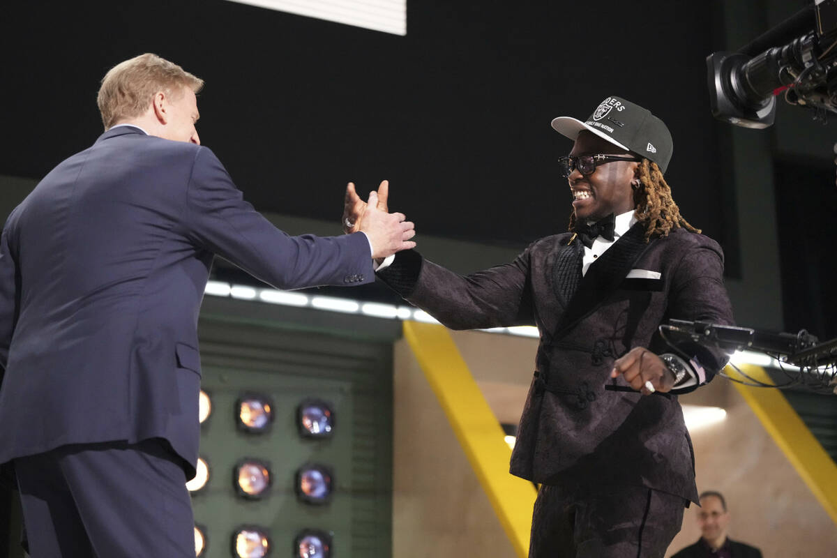 Boise State running back Ashton Jeanty, right, embraces NFL Commissioner Roger Goodell after be ...