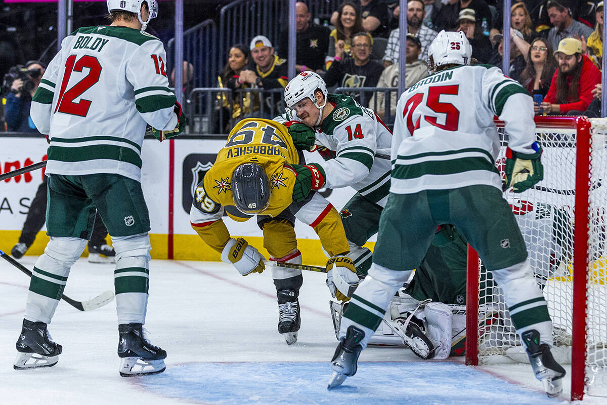 Golden Knights center Ivan Barbashev (49) is taken to the ice after a near score by Minnesota W ...