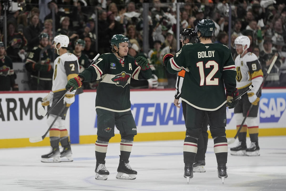 Minnesota Wild left wing Matt Boldy (12) celebrates toward left wing Kirill Kaprizov (97) after ...